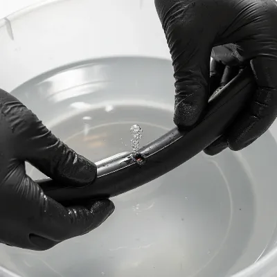 Person using soapy water to find a puncture on an electric scooter inner tube.